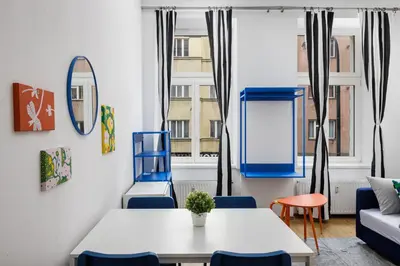 a living room with a table and chairs and a couch at Stay2gether - Grandma's Blues in Prague