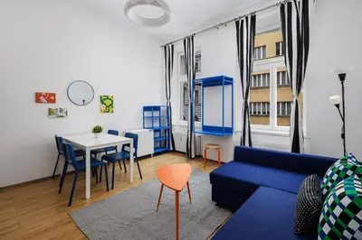 a living room with a blue couch and a table at Stay2gether - Grandma's Blues in Prague