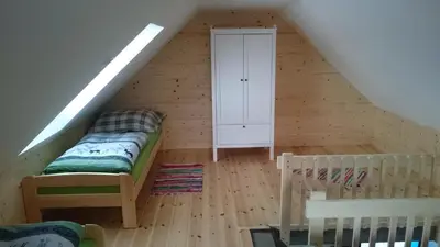 a attic room with a bed and a cabinet at Apartmány Vilekula Sázava in Sázava