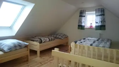 a attic room with two beds and two windows at Apartmány Vilekula Sázava in Sázava