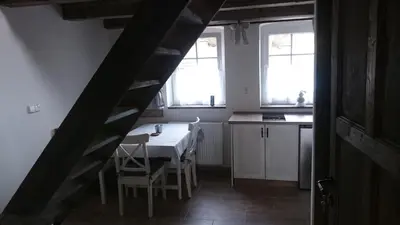 a kitchen with a table and chairs in a room at Apartmány Vilekula Sázava in Sázava