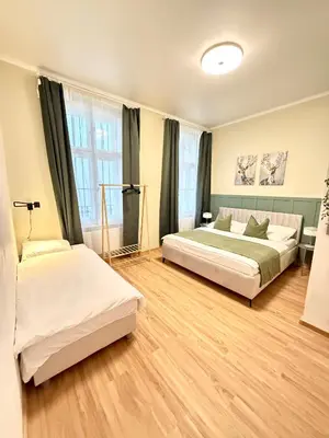 two beds in a large room with wooden floors at Stunning apartment in middle of Wenceslas Square in Prague