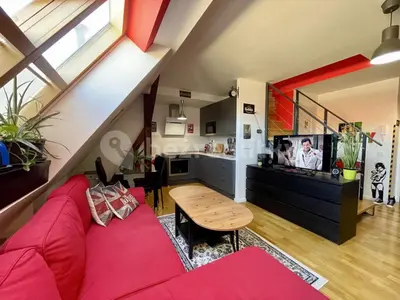 a living room with a red couch and a table at Podkrovní hnízdečko in Prague