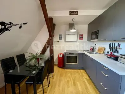a kitchen with a table and a counter top at Podkrovní hnízdečko in Prague