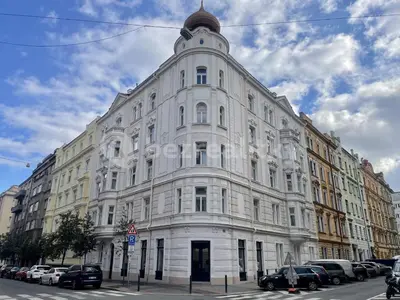 a large white building with cars parked in front of it at Podkrovní hnízdečko in Prague
