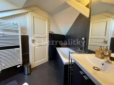 a bathroom with a white sink and a tub at Podkrovní hnízdečko in Prague