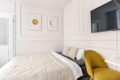 a bedroom with a bed and a tv and a chair at Anytime Holiday- Wenceslav Apartments in Prague