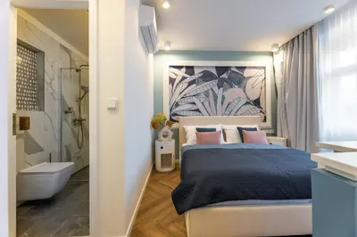 a bedroom with a king sized bed and a bathroom at Modern & Stylish Apartments Ječná in Prague