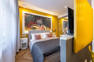 a bedroom with a bed and a flat screen tv at Modern & Stylish Apartments Ječná in Prague