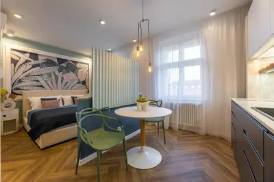 a small room with a bed and a table and a bedroom at Modern & Stylish Apartments Ječná in Prague