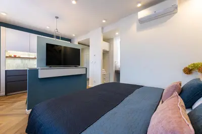 a bedroom with a bed and a flat screen tv at Modern & Stylish Apartments Ječná in Prague