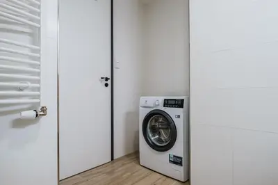 a washing machine in a room next to a door at Blueground Prague 7 furnished DOX museum PRG-25 in Prague