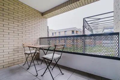 two chairs and a table on a balcony at Blueground Prague 7 furnished DOX museum PRG-25 in Prague