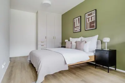 a bedroom with a bed and a green wall at Blueground Prague 7 furnished DOX museum PRG-25 in Prague