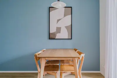 a table and two chairs in front of a blue wall at Blueground Prague 7 furnished DOX museum PRG-25 in Prague