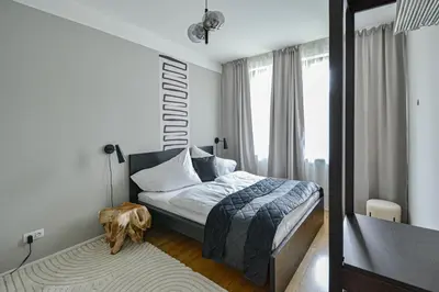 a small bedroom with a bed and a mirror at Japanese Design 3BDR Apartment in a Vibrant Area in Prague