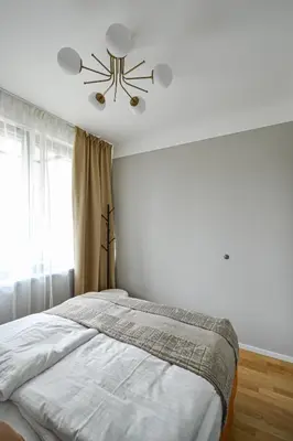 a bedroom with a bed and a ceiling fan at Japanese Design 3BDR Apartment in a Vibrant Area in Prague
