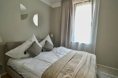 a bedroom with a bed with pillows and a window at Japanese Design 3BDR Apartment in a Vibrant Area in Prague