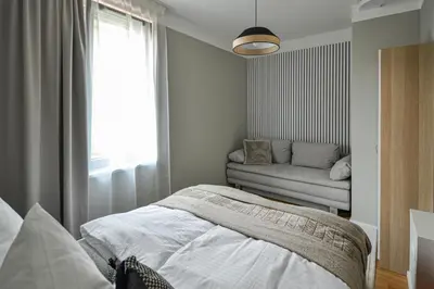 a bedroom with a bed and a window and a couch at Japanese Design 3BDR Apartment in a Vibrant Area in Prague