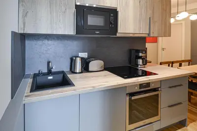 a kitchen with a sink and a microwave at Japanese Design 3BDR Apartment in a Vibrant Area in Prague