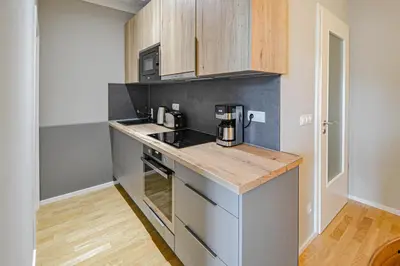 a kitchen with wooden cabinets and a counter top at Japanese Design 3BDR Apartment in a Vibrant Area in Prague