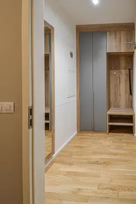 a hallway with a pivot door and wooden floors at Japanese Design 3BDR Apartment in a Vibrant Area in Prague
