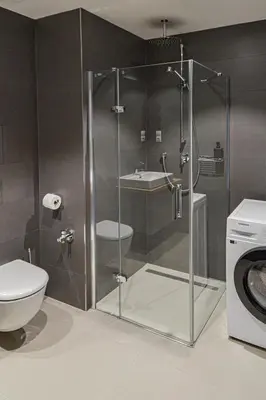 a bathroom with a shower with a toilet and a sink at Japanese Design 3BDR Apartment in a Vibrant Area in Prague