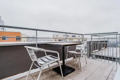 a table and two chairs on a balcony at Blueground Chodov New build free parking PRG-41 in Prague