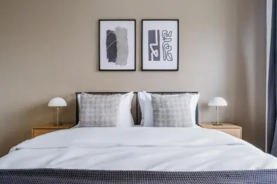 a bedroom with a white bed with two pictures on the wall at Blueground Chodov New build free parking PRG-41 in Prague