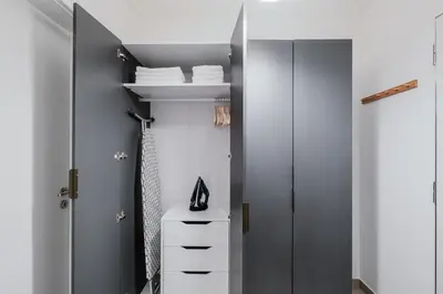 a walk in closet with gray walls and white cabinets at Blueground Chodov New build free parking PRG-41 in Prague