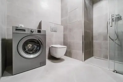 a bathroom with a washing machine and a toilet at Blueground Chodov New build free parking PRG-41 in Prague