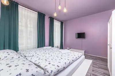 a bedroom with a large bed with purple walls at Selin Apartments in Prague