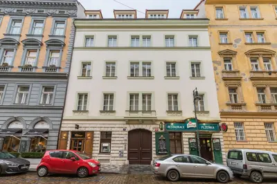 a white building with cars parked in front of it at Selin Apartments in Prague