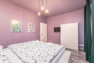 a bedroom with a large bed and purple walls at Selin Apartments in Prague