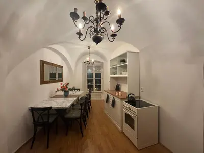 a kitchen with a dining table and a chandelier at Studio Melichar Trost in Prague