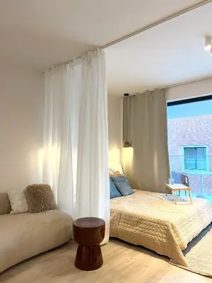 a bedroom with a bed and a couch and a window at Japandi Pearl Designed Studio,Parking ,Aircon, O2 in Prague