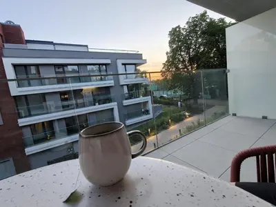 a coffee cup sitting on a table in front of a building at Japandi Pearl Designed Studio,Parking ,Aircon, O2 in Prague