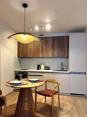 a kitchen with a table and chairs and a table and a light at Japandi Pearl Designed Studio,Parking ,Aircon, O2 in Prague