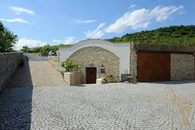 a stone building with a door and a driveway at Apartmány Vinice Salabka in Prague