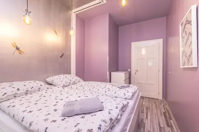 a bedroom with purple walls and a large bed at Veliant Apartments in Prague