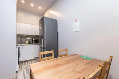 a kitchen with a wooden table and a refrigerator at Veliant Apartments in Prague