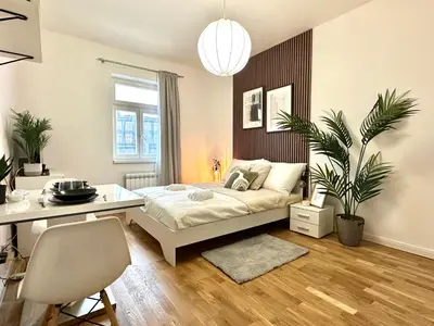a bedroom with a bed and a desk in it at Rentero Prague Central Apartment in Prague