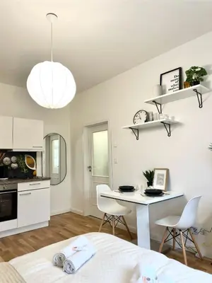 a kitchen and dining room with a table and chairs at Rentero Prague Central Apartment in Prague
