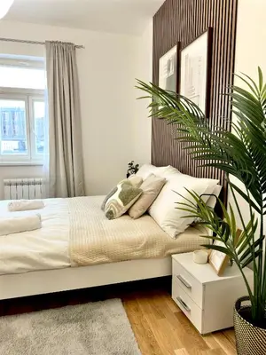 a bedroom with a bed and a potted plant at Rentero Prague Central Apartment in Prague