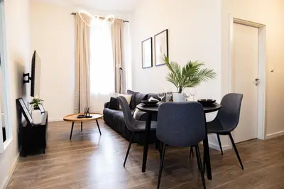 a living room with a table and a couch at Rentero Apartment, 5 min National Muzeum Modern Black Rose in Prague