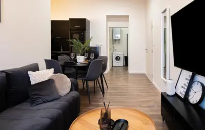 a living room with a couch and a table at Rentero Apartment, 5 min National Muzeum Modern Black Rose in Prague