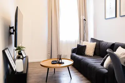 a living room with a couch and a table at Rentero Apartment, 5 min National Muzeum Modern Black Rose in Prague
