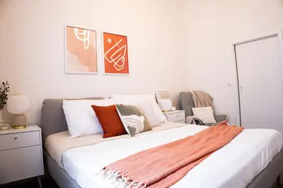 a bedroom with a large bed with orange and white pillows at Rentero Apartment, 5 min National Muzeum Modern Black Rose in Prague