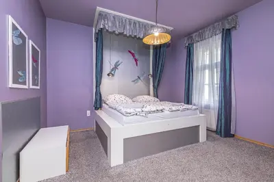 a bedroom with a bed in a purple room at Antiveli Residence in Prague