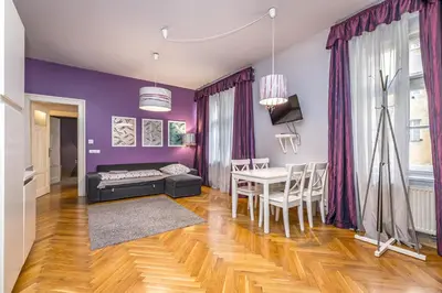 a living room with purple walls and a table and chairs at Antiveli Residence in Prague